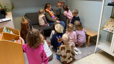 Pædagog der læser for børn