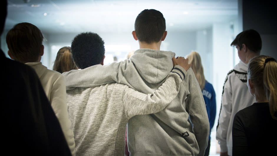 Unge drenge set bagfra med armen om hinanden